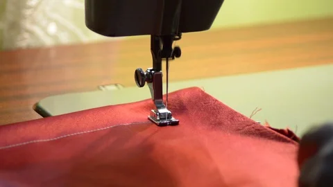 Needle in sewing machine knitting a red fabric Stock Footage 86991164