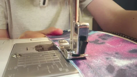 The needle of a sewing machine makes a thread stitch. Sewing white fabric on a Stock Footage 269811846