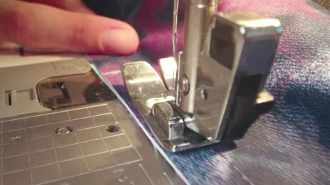 The needle of a sewing machine makes a thread stitch. Sewing white fabric on a Stock Footage 269812145