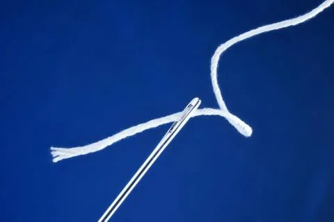 Needle sewing pointed tool and thread threaded into the eye of the needle. Stock Photos