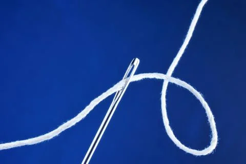 Needle sewing pointed tool and thread threaded into the eye of the needle. Stock Photos