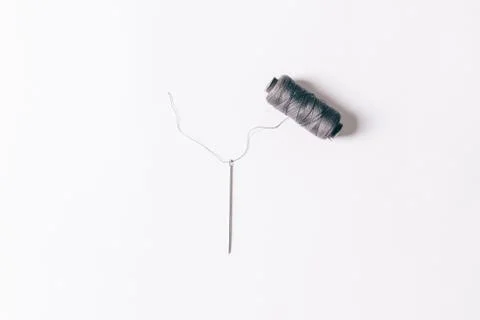 Needle with spool of thread on white background Stockfoto's