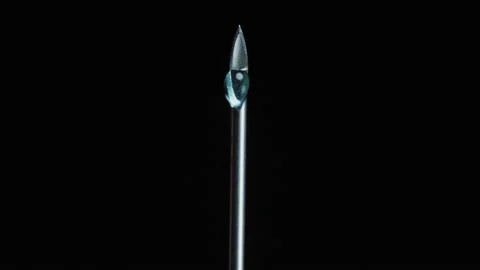 Needle of syringe with liquid drop at end. metal needle with a sharp point Vidéo 144113912