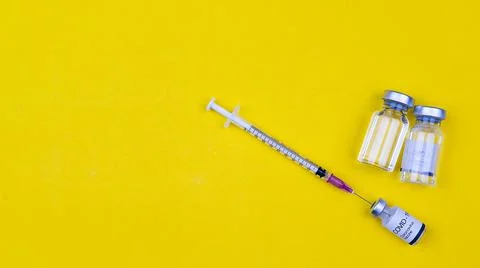 The needle of syringe stab inserts to a bottle of Covid-19 coronavirus vaccin Stock Photos