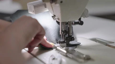 Needle with thread sewing machine works workshop. Sewing tailor products from Stock Footage 200052824