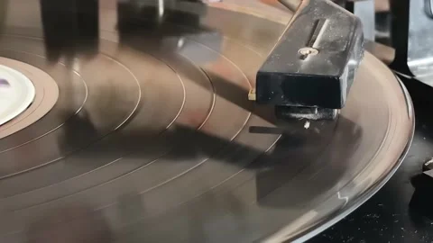 The needle of a turntable playing the tracks of a black vinyl record. Stock-Footage 158449821