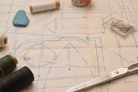 Needles, threads of different colors and scissors cut on a pattern printed on Foto stock