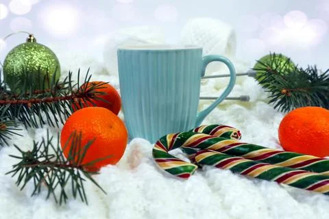 Needlework in winter. Knitting from white yarn, on it a cup of tea, tangerine Stock Photos