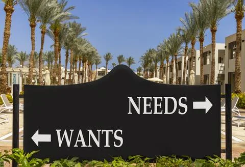 Needs instead wants words symbol. Concept words Needs Wants on beautiful bl.. Photos
