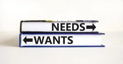 Needs or wants symbol. Concept word Needs or Wants on beautiful books. Beau.. Illustrazione stock