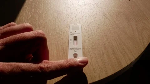 Negative covid test at accelerated speed on wooden background with man's hand 動画素材 260755358