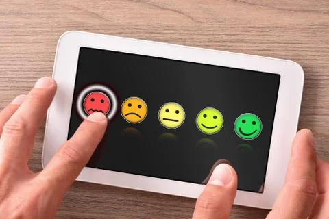 Negative evaluation on tablet with dark background on wooden table Stock Photos