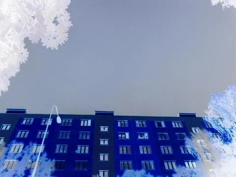 Negative image - Block of flats under storm cloud covered sky,but illuminated by Stock Photos
