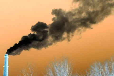 Negative image of an industrial pipe from which smoke goes to the sky above t Stock Photos
