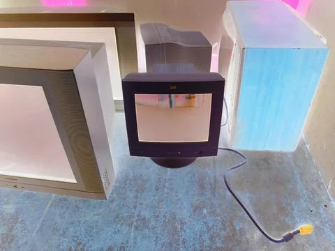 Negative image - Multiple old computer monitors and TVs inside of electric waste Stock Photos