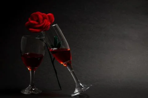 Negative Space two wine glasses toasting each other and one rose standing Stock Photos