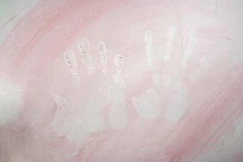 Negative stencil of two human hand prints created with red pigment on a tex.. Stock Photos