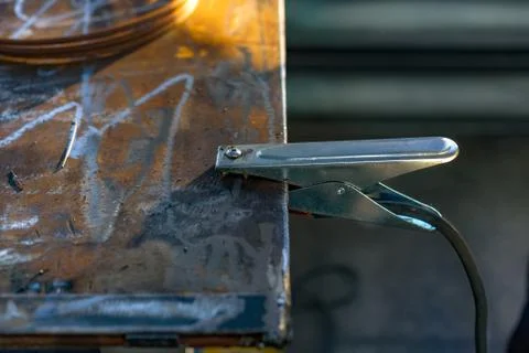 The negative wire of the welding machine with a pin is attached to the metal  Foto stock