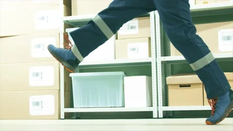 Neglectful warehouse worker or courier kicks a parcel on the storage floor, slow 库存影片 145803943