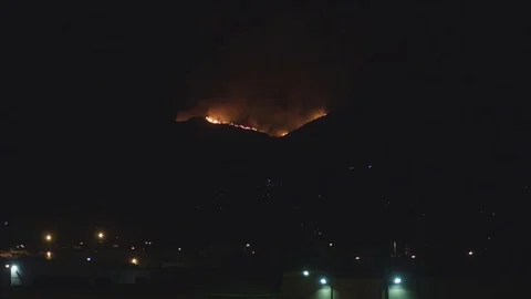 Neighborhood with flames on hillside Stock Footage 79606257