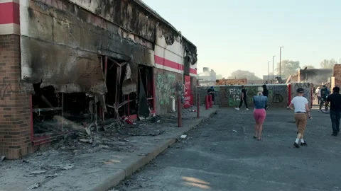 Neighbors examine the damage after Minneapolis riots erupt in response to Stock Footage