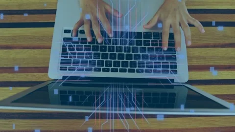 Neon circuits appearing on striped table, hands typing on laptop boosting data Stock Footage 335316729