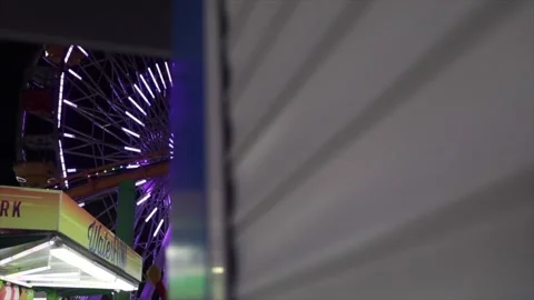 Neon light lit big ferris wheel ride in Pacific Park at Santa Monica beach Stock Footage 135797917