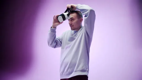 Neon light studio close-up portrait of man model putting on virtual reality Stock Footage 151754901
