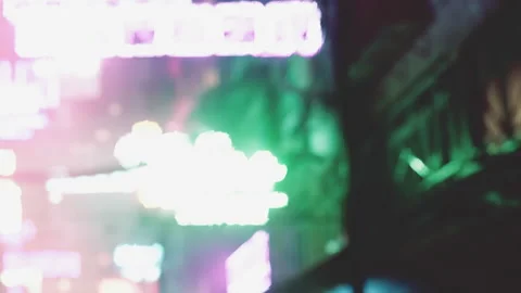 Neon Lights Create a Vibrant Atmosphere in a Bustling City Street at Night Stock Footage 346691391