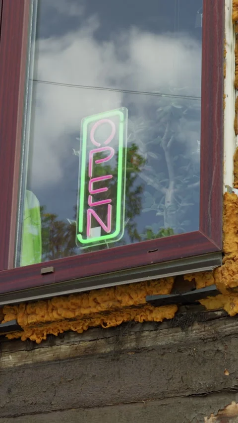 Neon open sign glowing in window with cloud reflections on wooden storefront Stock Footage 345765982