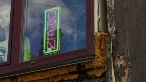 Neon open sign in weathered window beside peeling wall and textured facade of Stock Footage 345765900