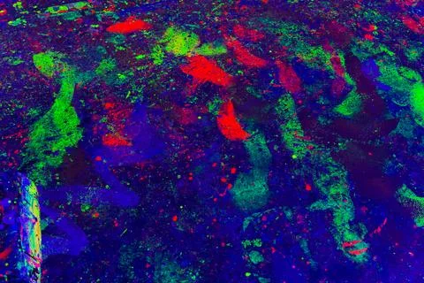 Neon Paint Splashes Glowing Under Blacklight With Red Green and Blue Drips Stock Photos