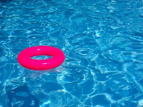 Neon Pink Inflatable Pool Ring In Swimming Pool Stock Photos