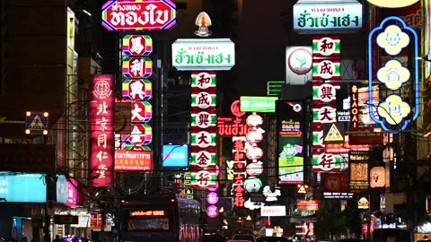 Neon shop signs glow above Chinatown traffic Vidéo 339002953