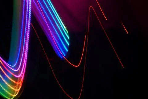 Neon wave pattern. Abstract lines isolated on a black background. Luminous Stock Photos