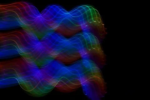 Neon wave pattern. Abstract lines isolated on a black background. Luminous Stock Photos