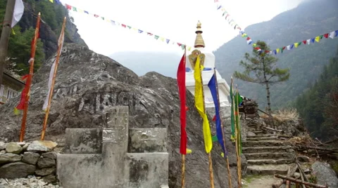 Nepal Himalayas  Prayer flags stand errect before a small Stupa along the path Stock-Footage 45208525