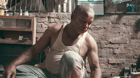 Nepali blacksmith in his workshop, hammering a metal rod on an anvil Stock Footage 132929921