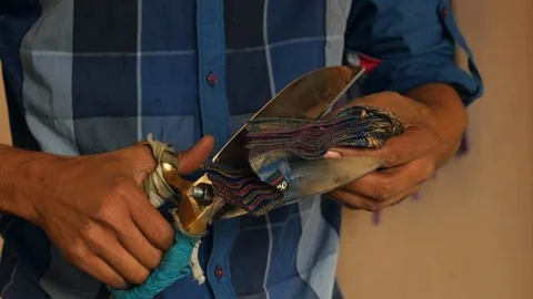 Nepalise worker trims small patch of multicolored fabric in Kathmandu workshop Stock Footage 119341065