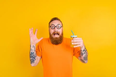 Nerd afraid man with glasses drinks a fruit juice Stock Photos