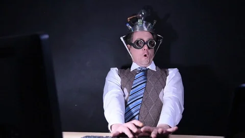 Nerd with aluminum hat sits in front of the PC and taps on the keyboard Stock-Footage 104326218