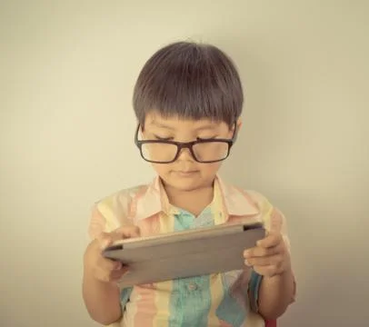 Nerd boy with eyeglasses is using a tablet 库存照片