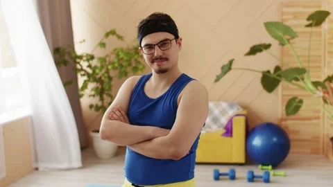 Nerd Chubby man with a moustache, glasses and headband in blue and yellow Stock Footage 221267964