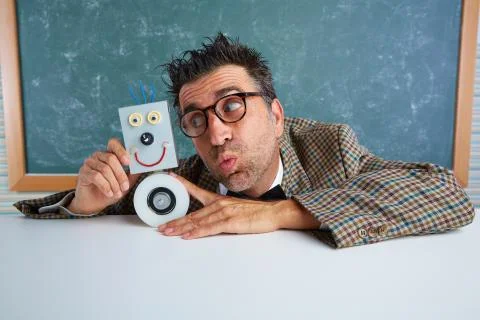 Nerd electronics technician with self made robot Stock Photos