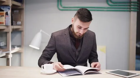 Nerd hipster guy with glasses sitting at bar table and using a tablet Stock Footage 57112155