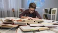Nerd kid making abstruse calculations and comparing formulas sitting in his room HD Footage