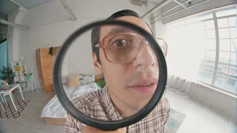 Nerd looks through magnifier Stock Footage 137514113