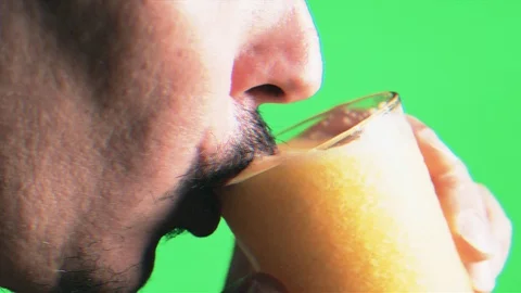 Nerd mustache man drink orange juice glass on green screen background disturbing Stock Footage 129777577