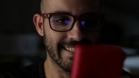 Nerd plays with a little red retro video game. Male game player. Portrait shot Stock Footage 136856320