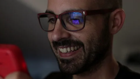 Nerd plays with a little red retro video game. Male game player. Portrait shot Stock Footage 136905765